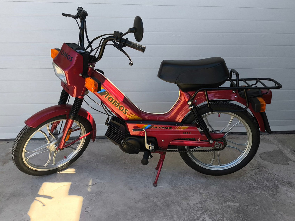 A red Tomos moped